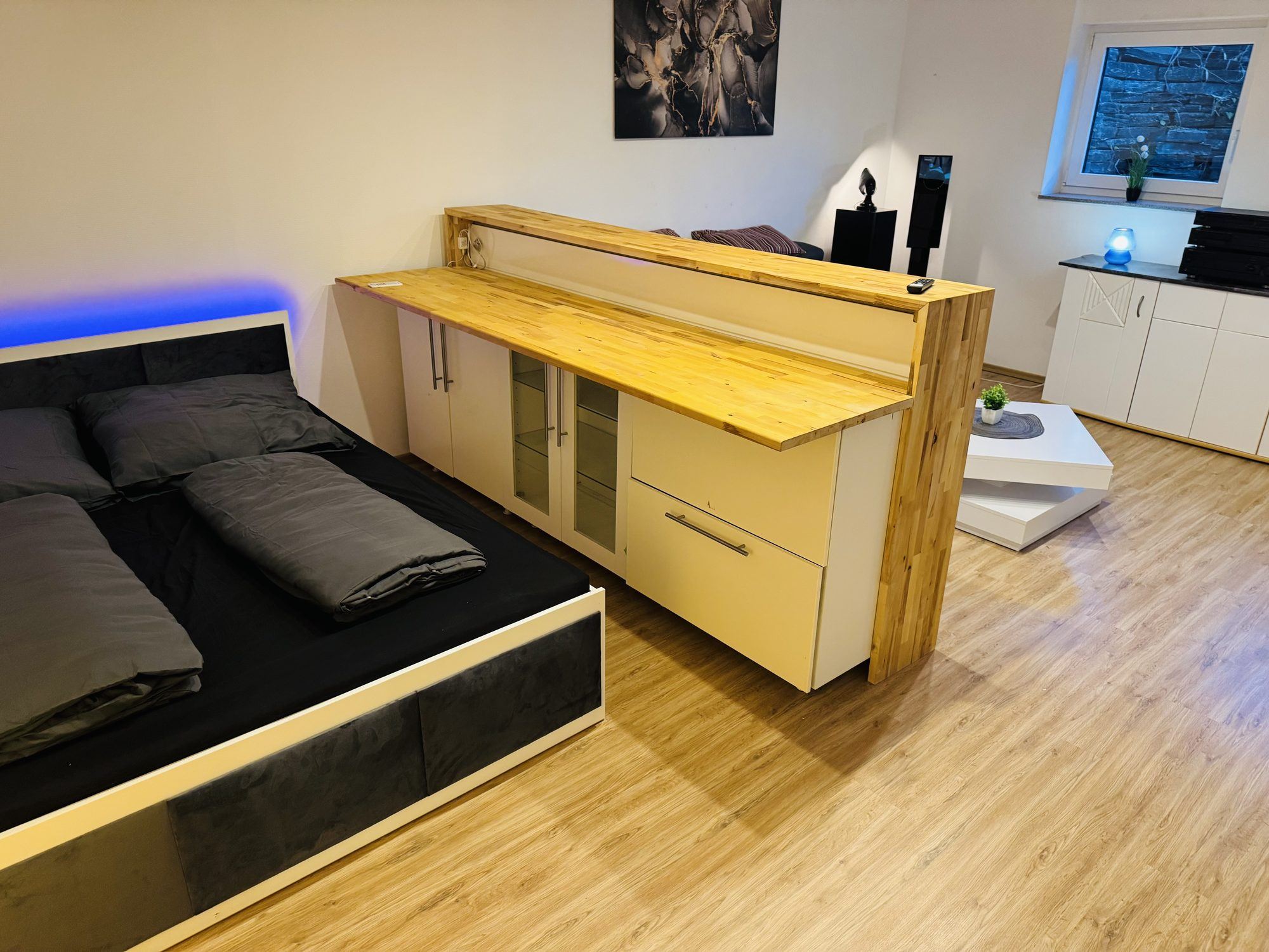 Schlafbereich mit Doppelbett und Sideboard
